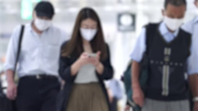 Crowd of people wearing masks walking to work in Tokyo, JAPAN / 4K blur