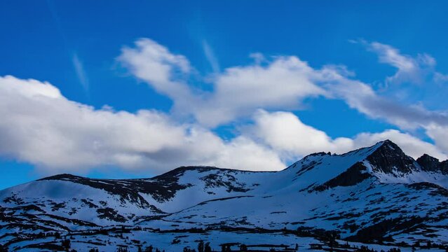Time Lapse - Beautiful cloudscape moving over snowcapped mountain ranges