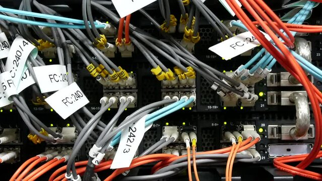 many fiber optic cable network connected to internet switch servers in data center.