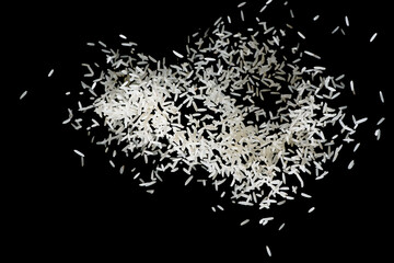 Raw white rice explosion. Heap of raw rice on dark background. faling rice on black background