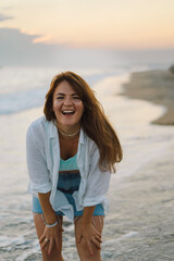 Portrait of a happy young woman on a background of beautiful sea. The girl looks at the magical sea. Freedom and happiness