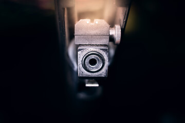 Empty air rifle bullet hole close-up on a dark background.