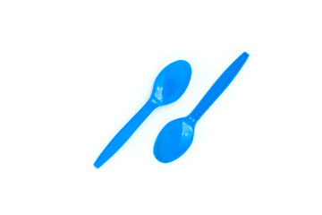 Blue plastic spoons on white background