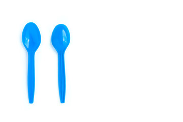 Blue plastic spoons on white background