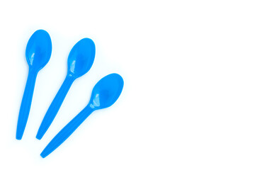 Blue plastic spoons on white background