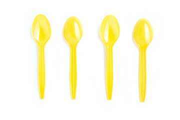 Yellow plastic spoons on white background