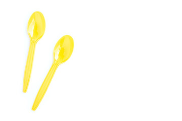 Yellow plastic spoons on white background