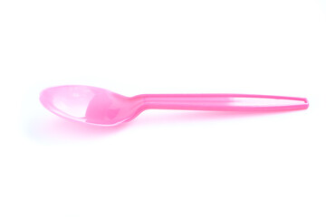 Pink plastic spoon on white background