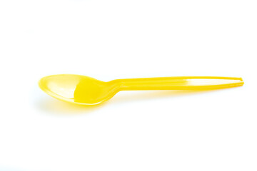Yellow plastic spoon on white background