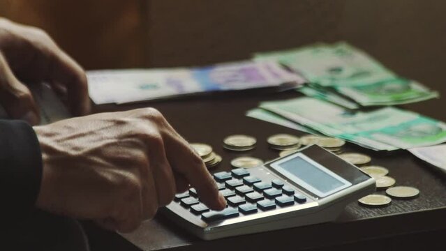 luego de recibir su sueldo, un hombre joven esta contando el dinero que gano y as&iacute; prepara el presupuesto para el pr&oacute;ximo mes