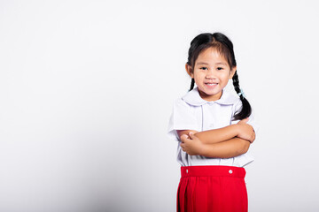 Asian toddler smile happy wearing student thai uniform red skirt stand with arms folded in studio shot isolated on white background, Portrait little children girl preschool crossed arm, Back to school