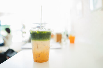 takeaway cup of ice coffee latte mixed with milk and green tea