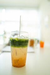 takeaway cup of ice coffee latte mixed with milk and green tea