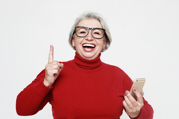 Modern Communication. Happy senior woman using mobile phone over white background.