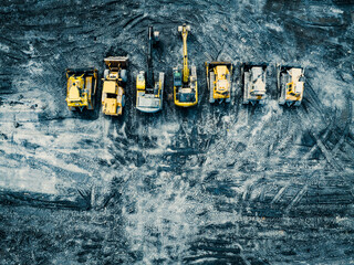 Aerial View of Coal Excavation Site with Multiple Heavy industry Vehicles.