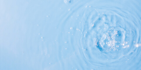 Naklejka na ściany i meble Pouring and splashing clear water on light blue background upper close view