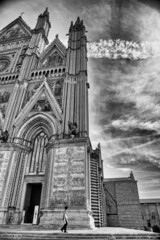 Fototapeta na wymiar Orvieto, Italy - July 3, 2021: Exterior view of city Cathedral on a beautiful sunny day