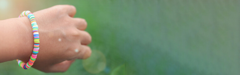 Rainbow bracelet on green background.lgbt concept. happy earth day.copy space