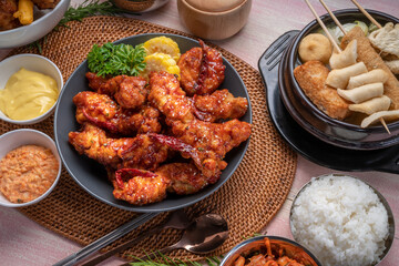 Gang Jeong chicken or crispy and tender Korean fried chicken smothered in a sticky, spicy red sauce Served with kimchi, dipping sauce, rice and sweet corn.