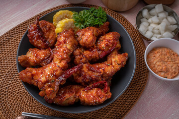 Gang Jeong chicken or crispy and tender Korean fried chicken smothered in a sticky, spicy red sauce Served with kimchi, dipping sauce, rice and sweet corn.