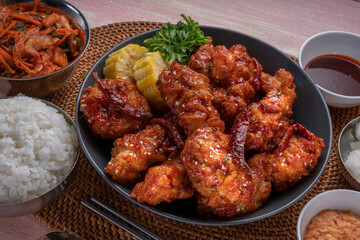Gang Jeong chicken or crispy and tender Korean fried chicken smothered in a sticky, spicy red sauce Served with kimchi, dipping sauce, rice and sweet corn.