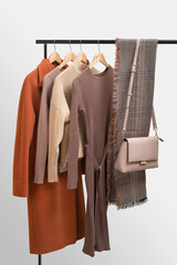 Basic autumn women's wardrobe concept on railing in showroom. Woman collection of clothes on a...