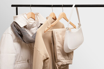 Basic autumn women's wardrobe concept on railing in showroom. Woman collection of clothes on a...