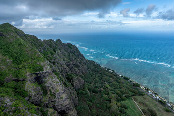 Fototapeta na wymiar Mountain peaks by the ocean leading to deep valley with clouds above the tops, Oahu Island, Hawaii