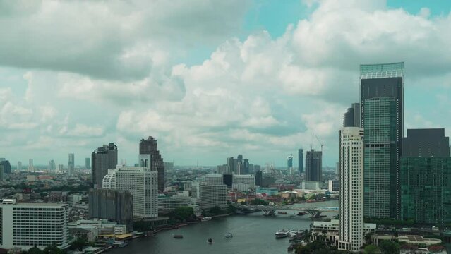Panning shot of Chao Phraya River with King Taksin bridge and building of Bangkok city, Thailand