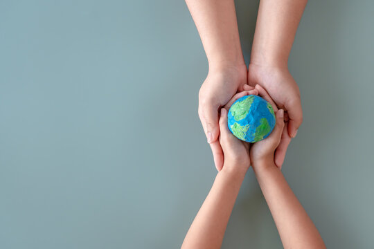 Hands holding earth paper and water paint. Concept of protecting the world from global warming. Sustainability topic to save the world.