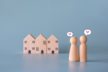 Small wooden faceless figures of human family members with heart icon and house. Property, hospitality, orphanage concept using wooden house and human model. - obrazy, fototapety, plakaty