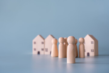 Small wooden faceless figures of human family members and house. Property, hospitality, orphanage concept using wooden house and human model.