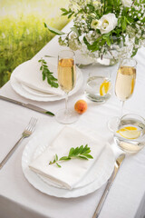 Wedding teble decoration with white flowers, glasses and white napkins. Elegantly decorated table at a wedding reception. Festive table setting. The wedding decor.