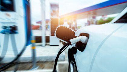 EV car charging at outdoor electric car charging station. EV car charging point. Electric vehicle fast charge concept. DC fast charging station. Quick charge concept. Sustainable power. Green energy.