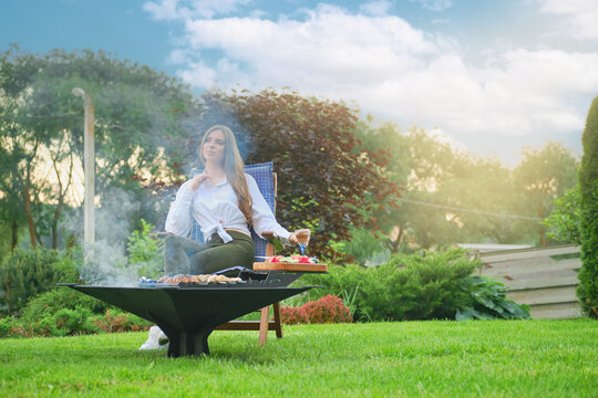 Pensive woman cooking vegetarian shashlik on barbecue