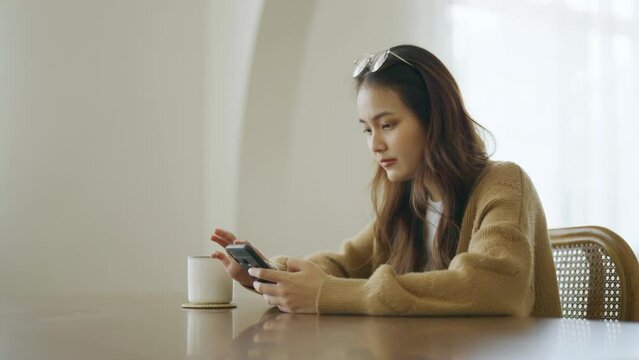 Young asian woman using mobile smartphone. Asian female thinking and lonely at home