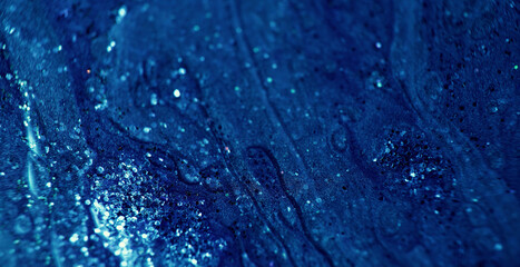 Glitter fluid. Wet ink texture. Shiny liquid mix. Defocused dark blue shimmering paint flow motion. Abstract art background shot on RED Cinema camera.
