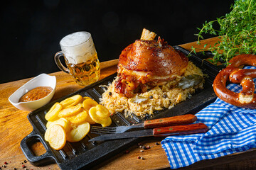 Fototapeta na wymiar rustic pork knuckle with sauerkraut, sweet mustard and fried potatoes
