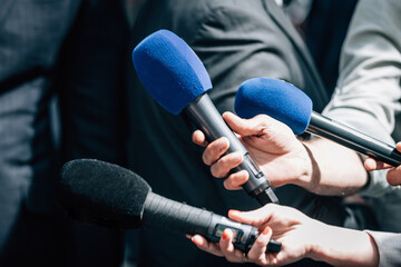 ews reporters holding microphones, taking an official statement