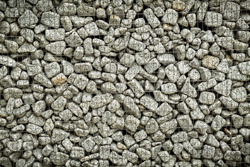 Textured background of a stone wall with iron netting.