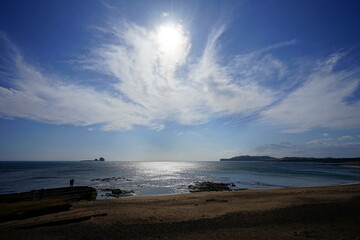 rock beach and people and distant island