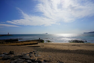 rock beach and people and distant island