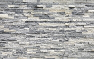 Stone cladding wall made of regular  bricks of white, gray and black rocks. Panels for exterior, background and texture.	