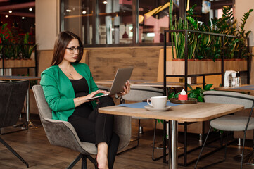Female freelancer is working with a laptop in the indoors the cafe or coworking area