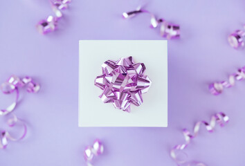 gift box with festive confetti on pastel light purple background top view