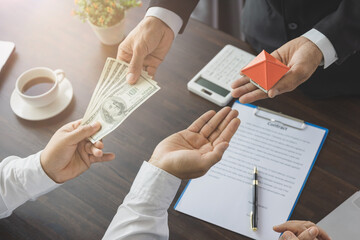 Real estate agent showing new house and bank note from Saving account for home insurance. House purchase contract.