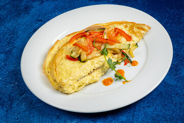 fresh omelet with vegetables on the white plate