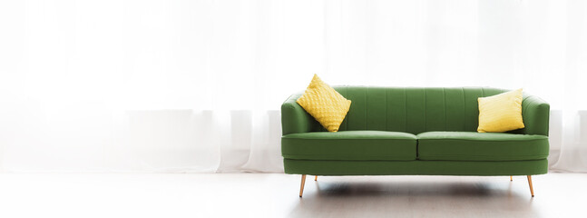 Renovation of apartment. Cozy green sofa with yellow pillows on window backgrounds. Banner with...