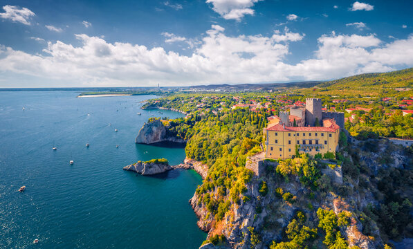 Impressive summer view from flying drone of Duino Castle. Fantastic morning scene of Adriatic coast of Italy, Europe. Beautiful cityscape of Duino town. Traveling concept background.