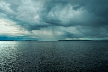 Cloudy rainy weather. Beautiful dark dramatic sky and lake.